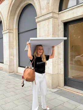 Mit einer Papierrolle unterwegs vor dem Büro